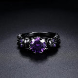Anillo vintage redondo negro con una piedra preciosa morada